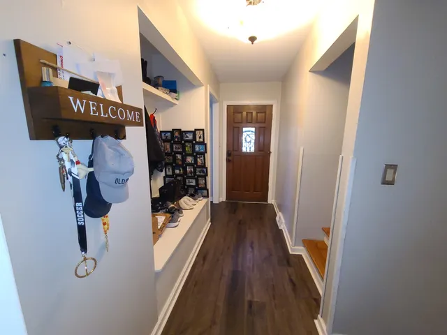 a view of a hallway with wooden floor and entryway