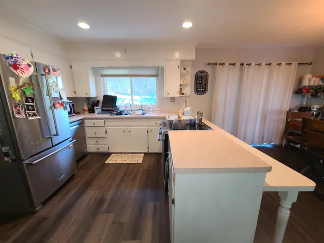 a kitchen with stainless steel appliances a refrigerator a stove a microwave a sink and a refrigerator