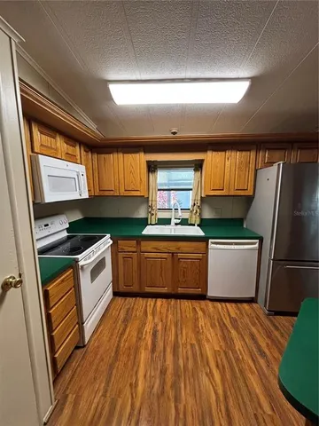 a kitchen with stainless steel appliances wooden floors and a stove