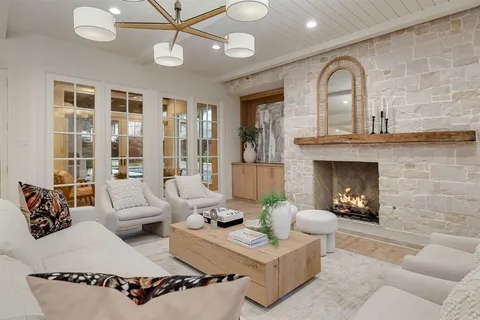 a living room with furniture a fireplace and a chandelier
