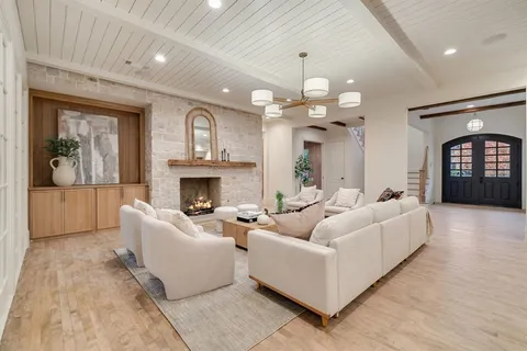a living room with furniture a fireplace and a chandelier