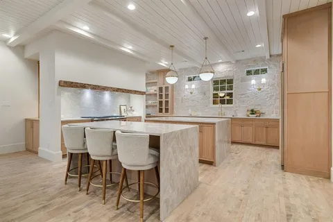 a kitchen with stainless steel appliances kitchen island granite countertop a sink and cabinets