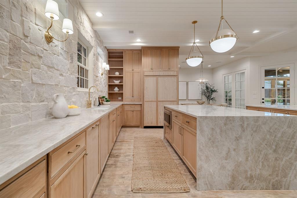 6411 Orchid Lane Dallas, TX 75230 - Photo 20 of 40 a large kitchen with kitchen island a large counter space a sink and stainless steel appliances