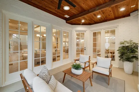 a living room with furniture and potted plants