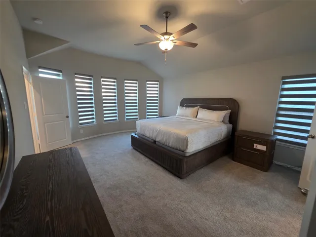 a spacious bedroom with a bed and a chandelier
