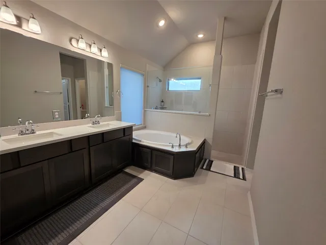 a bathroom with a tub sink and mirror