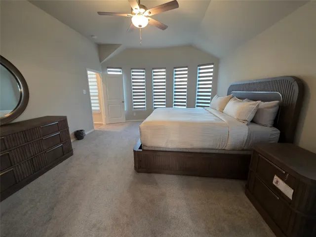 a spacious bedroom with a bed and a chandelier