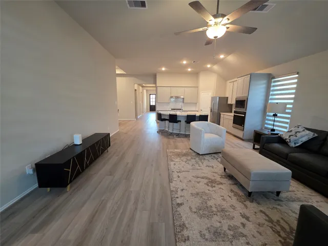 a living room with furniture and kitchen view