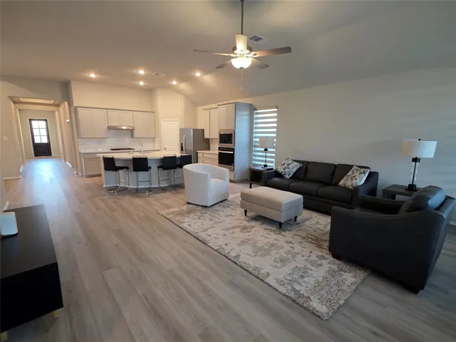 a living room with furniture and kitchen view