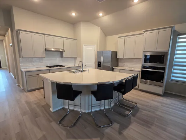 a large kitchen with kitchen island a dining table chairs and a sink