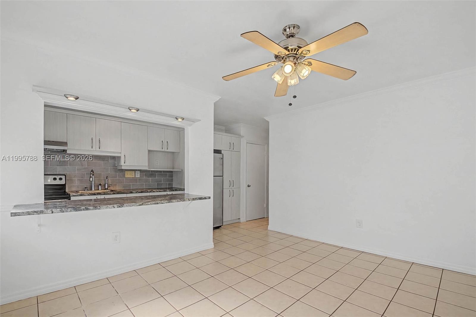 60 Northwest 79th Street, Unit 23 Miami, FL 33150 - Photo 4 of 23 a kitchen with granite countertop a stove a sink and a refrigerator