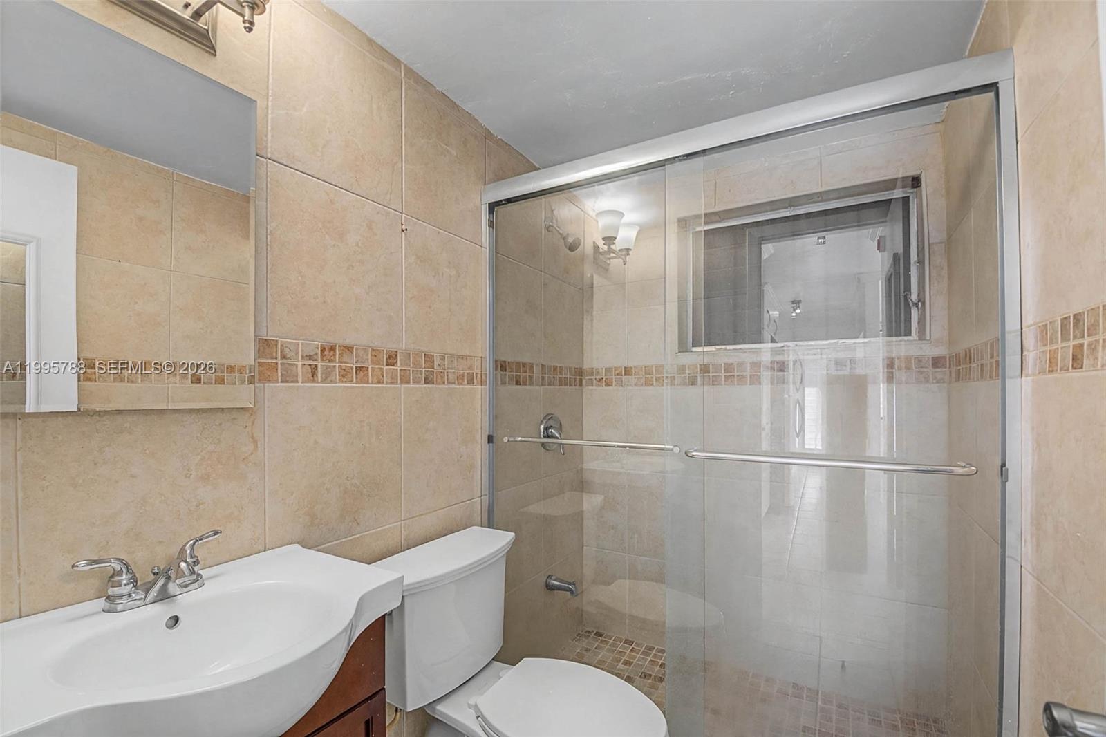 60 Northwest 79th Street, Unit 23 Miami, FL 33150 - Photo 8 of 23 a bathroom with a sink mirror and toilet