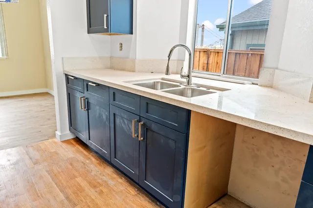 a kitchen with a sink and a wooden floor