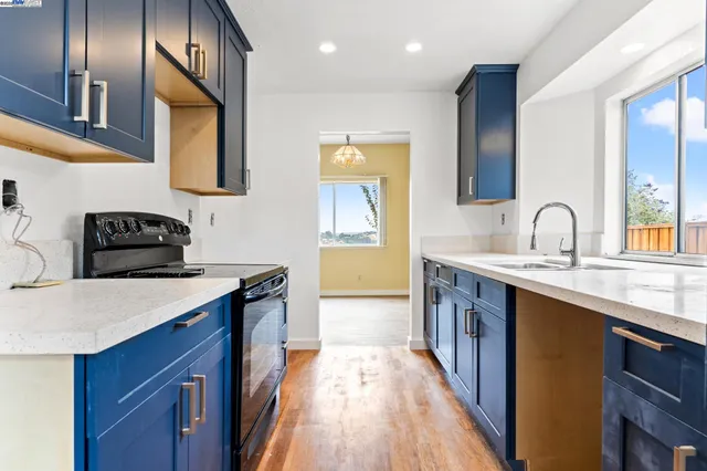 a kitchen with stainless steel appliances granite countertop a sink stove and cabinets