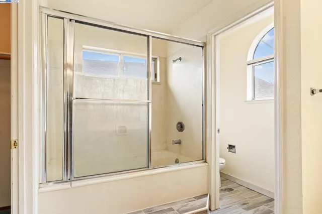 a bathroom with a shower and a glass door
