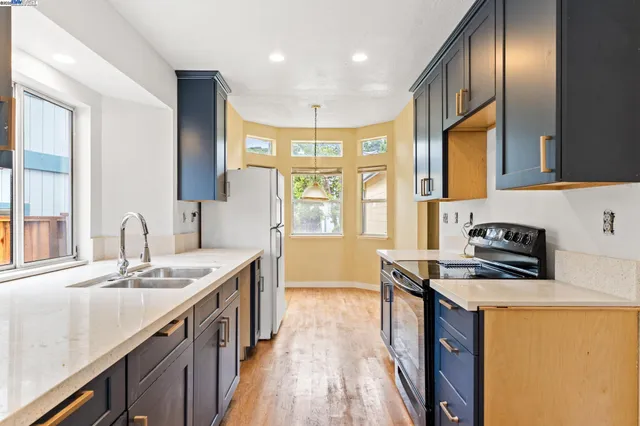 a kitchen with stainless steel appliances granite countertop a sink stove and cabinets