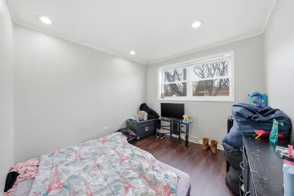 a bedroom with a bed and a wooden floor