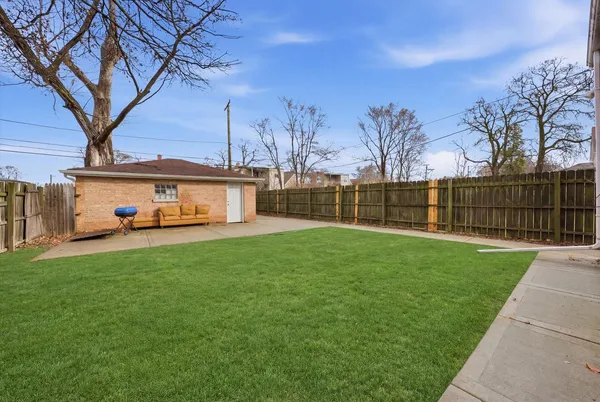 a view of a house with backyard and a tree