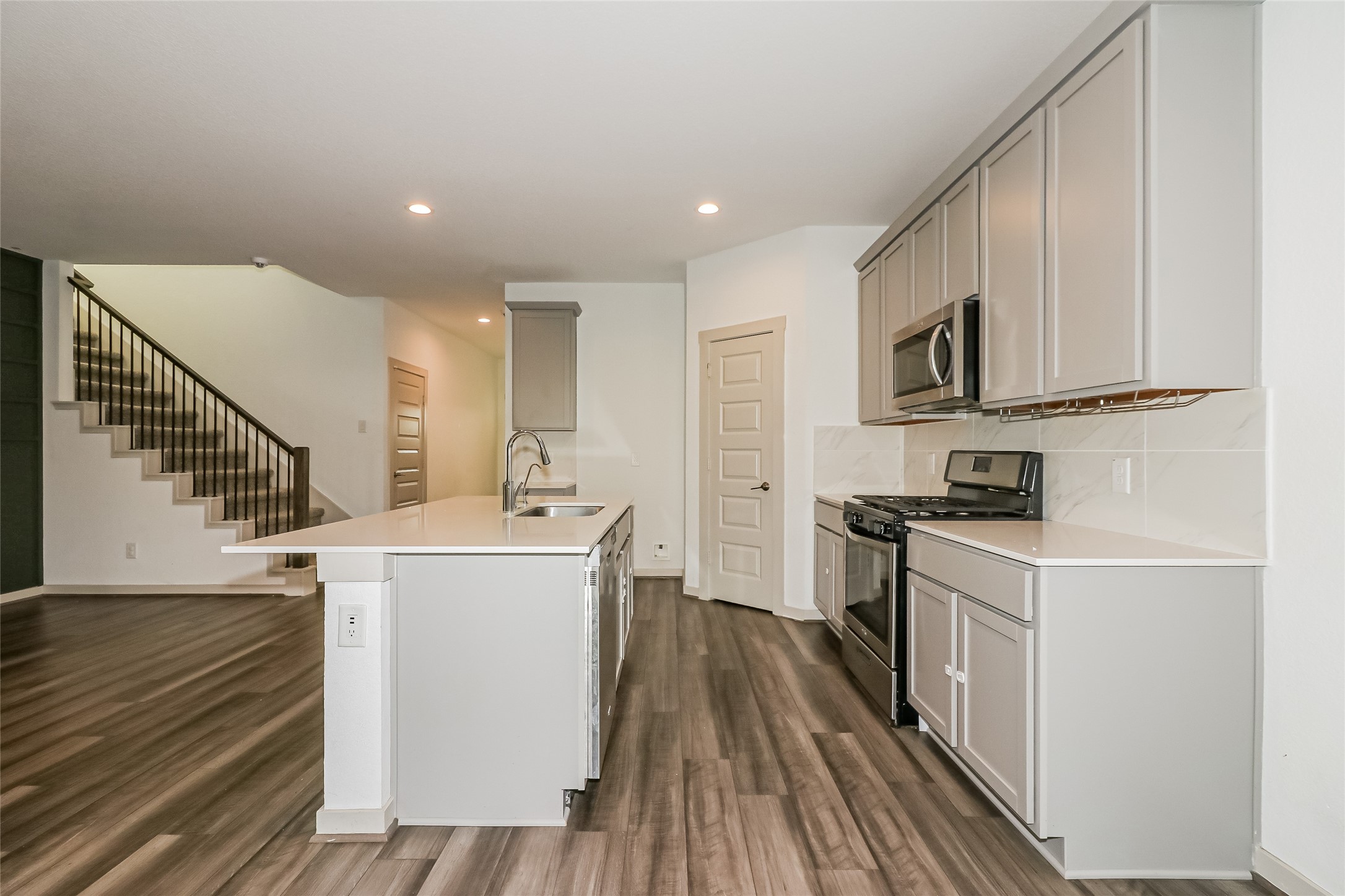 7322 Ramsgate Cliff Lane Richmond, TX 77407 - Photo 8 of 17 a kitchen with a sink a stove top oven and wooden floor