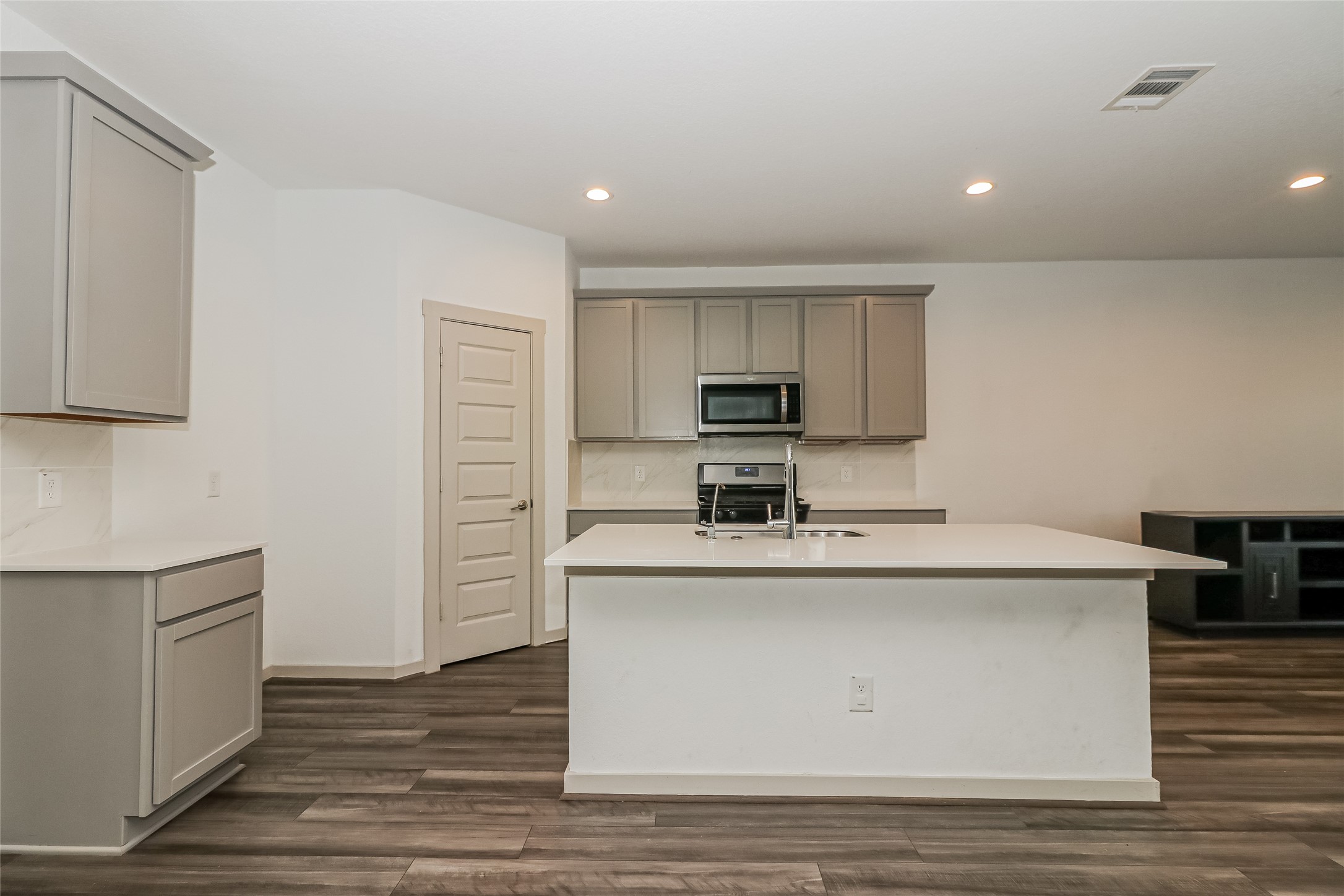 7322 Ramsgate Cliff Lane Richmond, TX 77407 - Photo 9 of 17 a kitchen with stainless steel appliances a sink and a stove top oven with wooden floor