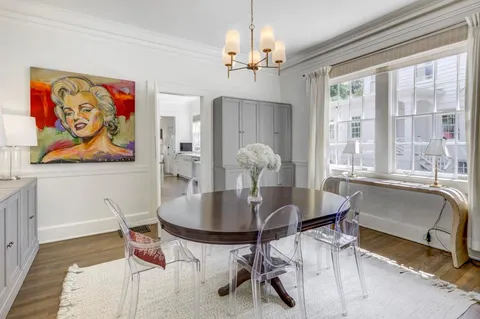 a dining room with furniture a chandelier and wooden floor