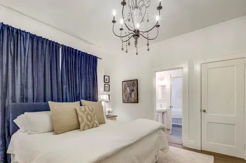 a bedroom with a large bed and a chandelier