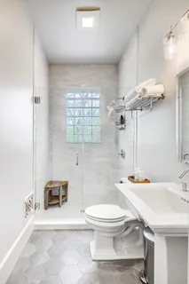 a bathroom with a sink a toilet a mirror and shower