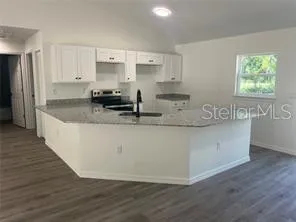 a kitchen with kitchen island granite countertop a sink a counter space and stainless steel appliances