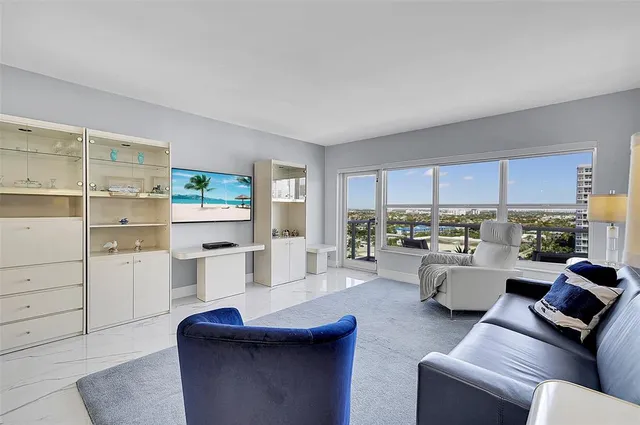 a living room with furniture and a floor to ceiling window