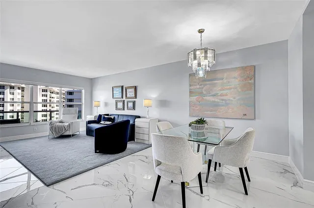a living room with furniture a chandelier and kitchen view