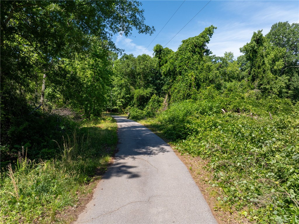 0 Ben Hurt Road Lyman, SC 29365 - Photo 10 of 21 A tranquil pathway meanders through verdant foliage under a clear blue sky.