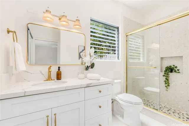 a bathroom with a sink a toilet and shower