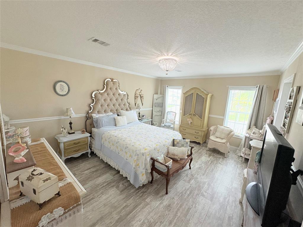 4331 Southwest 10th Way Okeechobee, FL 34974 - Photo 12 of 49 a spacious bedroom with a bed and wooden floor