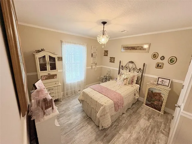 a spacious bedroom with a bed and a view of kitchen