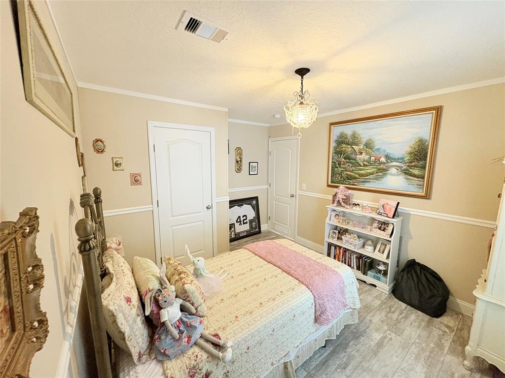 4331 Southwest 10th Way Okeechobee, FL 34974 - Photo 24 of 49 a bedroom with a bed a wall painting and a chandelier
