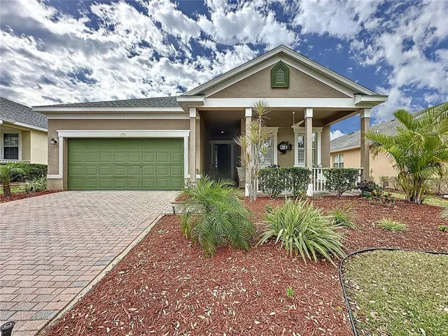 a front view of a house with a yard and potted plants
