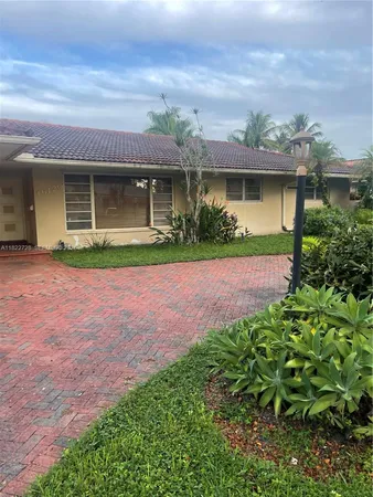 front view of a house with a yard and potted plants