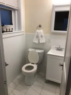 a bathroom with a toilet sink and mirror
