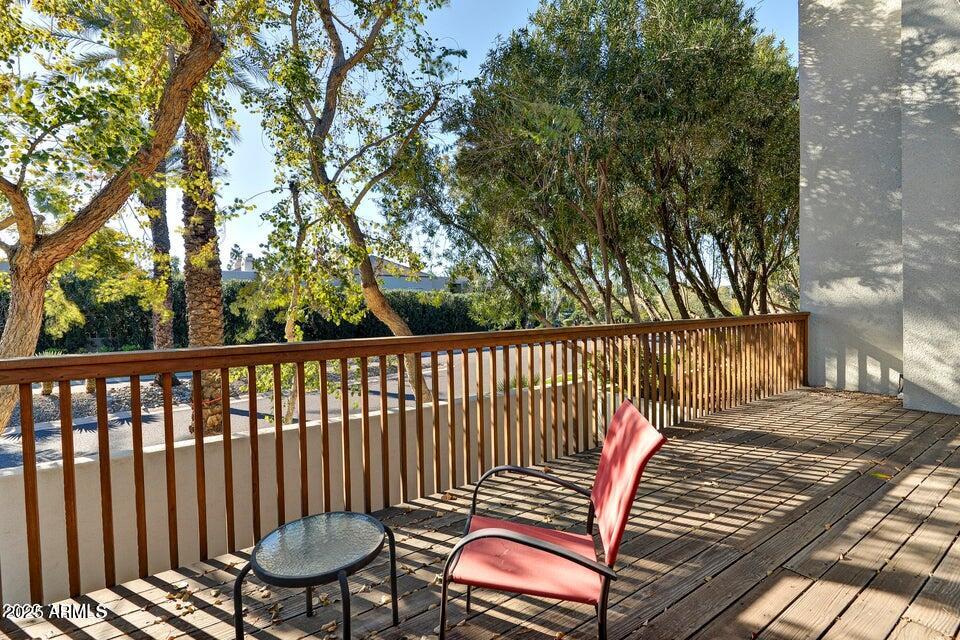 7700 East Gainey Ranch Road, Unit 104 Scottsdale, AZ 85258 - Photo 12 of 14 a balcony with wooden floor and fence