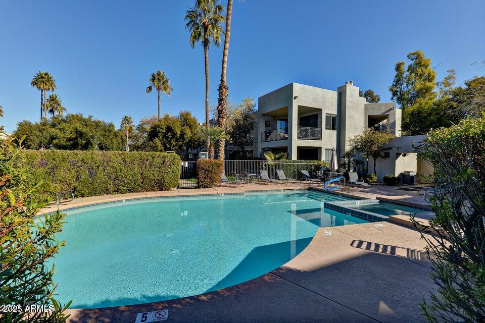 7700 East Gainey Ranch Road, Unit 104 Scottsdale, AZ 85258 - Photo 13 of 14 a view of a house with swimming pool and a yard