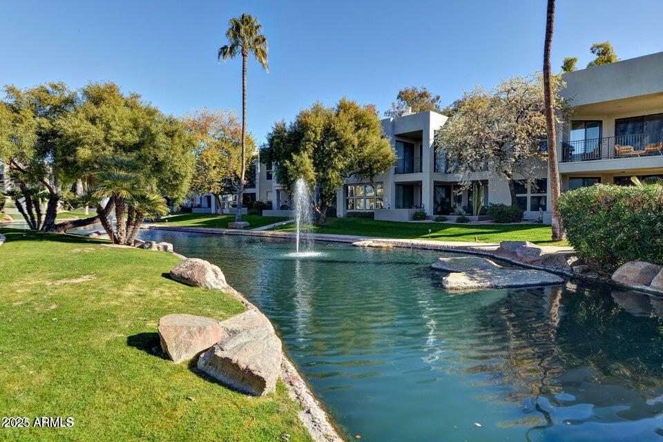 7700 East Gainey Ranch Road, Unit 104 Scottsdale, AZ 85258 - Photo 14 of 14 a view of a lake with a building in the background