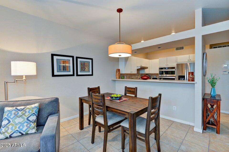 7700 East Gainey Ranch Road, Unit 104 Scottsdale, AZ 85258 - Photo 4 of 14 a dining room filled a chandelier and kitchen view
