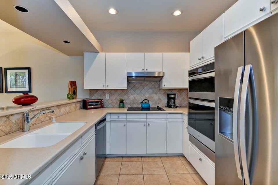 7700 East Gainey Ranch Road, Unit 104 Scottsdale, AZ 85258 - Photo 5 of 14 a kitchen with granite countertop a refrigerator sink and stove