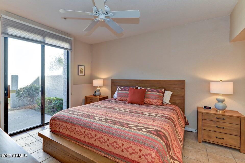 7700 East Gainey Ranch Road, Unit 104 Scottsdale, AZ 85258 - Photo 6 of 14 a bedroom with a large bed and a chandelier
