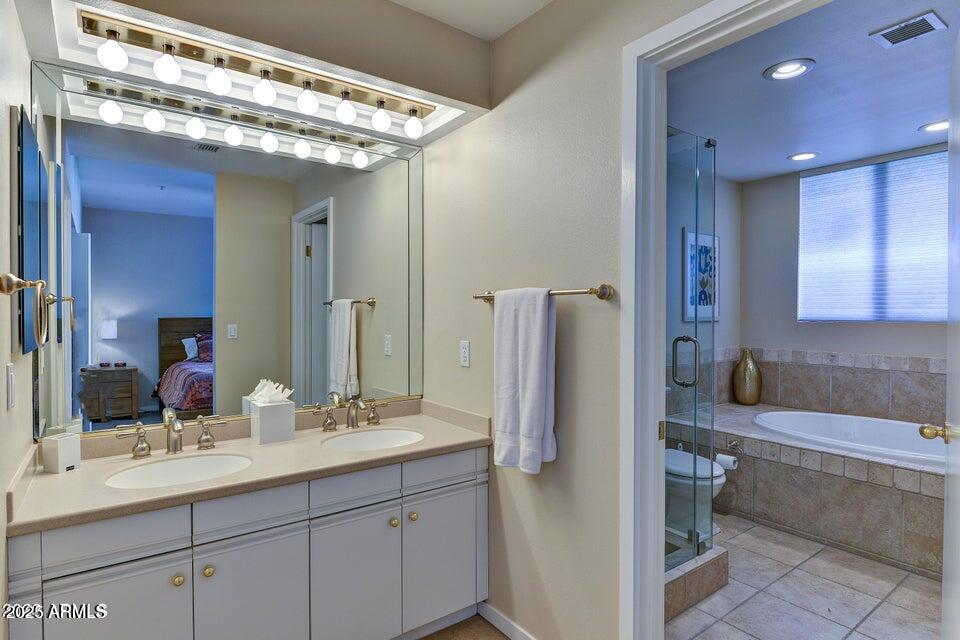 7700 East Gainey Ranch Road, Unit 104 Scottsdale, AZ 85258 - Photo 7 of 14 a bathroom with a double vanity sink and a mirror