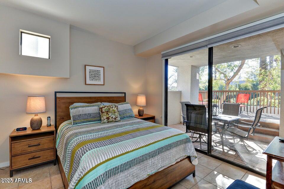 7700 East Gainey Ranch Road, Unit 104 Scottsdale, AZ 85258 - Photo 9 of 14 a bedroom with a bed and a lamp next to a window