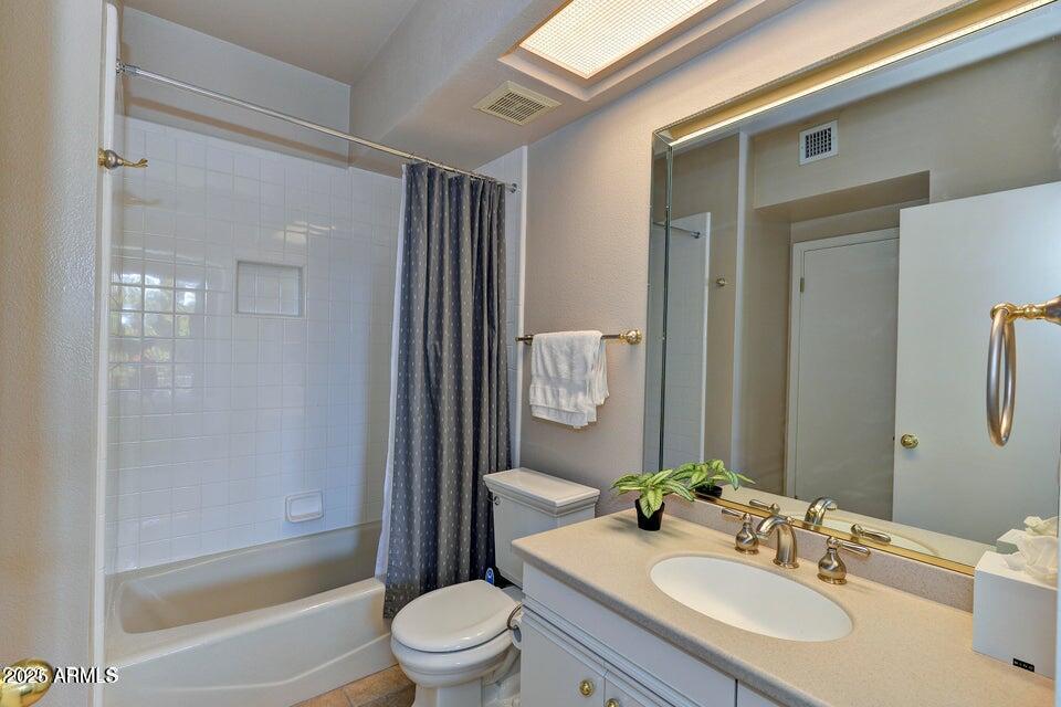 7700 East Gainey Ranch Road, Unit 104 Scottsdale, AZ 85258 - Photo 10 of 14 a bathroom with a granite countertop sink toilet and shower