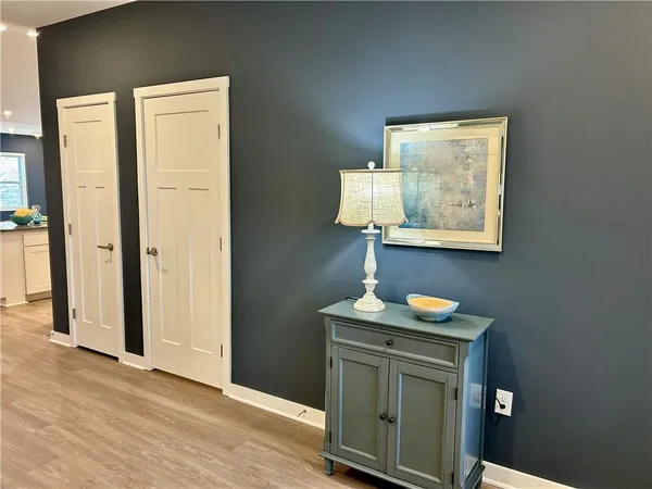 an entryway with wooden floor cabinet and a bathroom