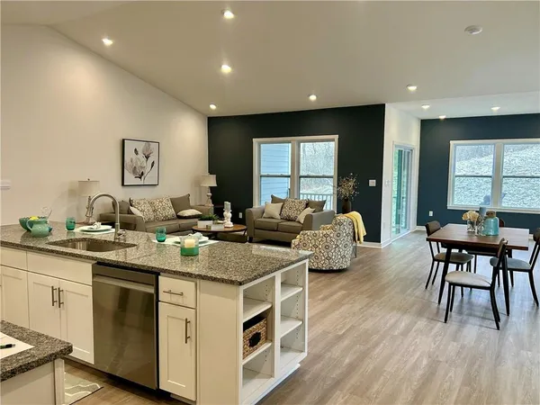 a kitchen with stainless steel appliances granite countertop a stove a sink a dining table and chairs