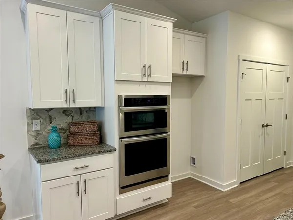 a kitchen with granite countertop white cabinets and stainless steel appliances